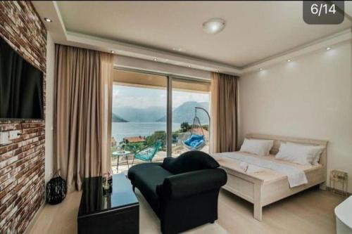 a bedroom with a bed and a view of the ocean at Apartment Sunset in Kotor