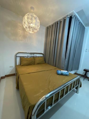 a bedroom with a bed and a chandelier at Sto. Niño Residences Standard Room in Lucena