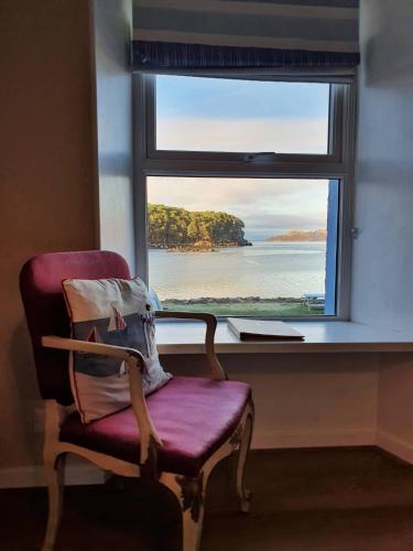 a chair sitting in front of a window at Tigh an Eilean Hotel in Shieldaig