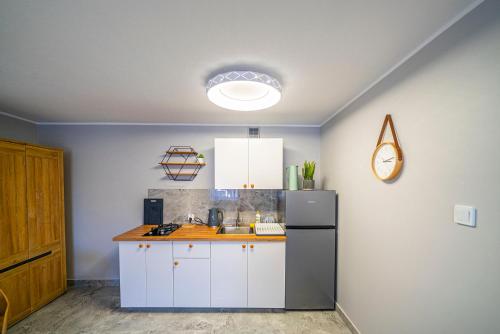 a kitchen with white cabinets and a refrigerator at Niebieska Willa in Jastarnia