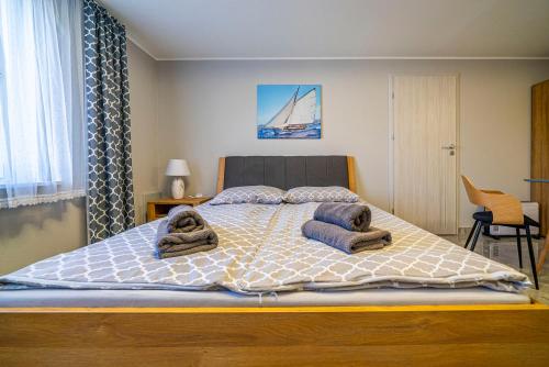a bedroom with a large bed with towels on it at Niebieska Willa in Jastarnia
