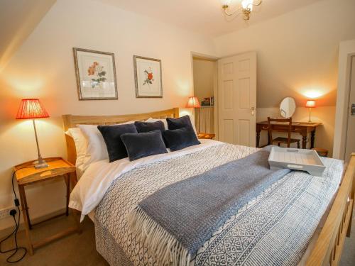 a bedroom with a bed with a blue and white comforter at Oma's Cottage in Moreton in Marsh