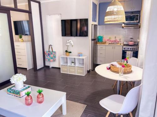 a living room with a table and a kitchen at Pink Paradise at Seascape. Getaway by the beach! in Riviera Beach