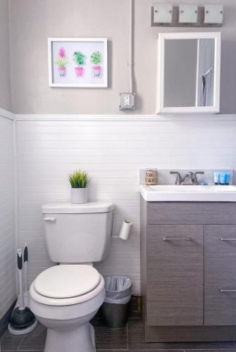 a white bathroom with a toilet and a sink at Pink Paradise at Seascape. Getaway by the beach! in Riviera Beach