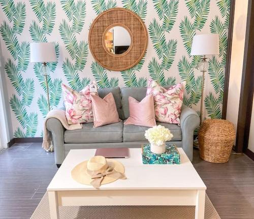 a living room with a couch and a table at Pink Paradise at Seascape. Getaway by the beach! in Riviera Beach