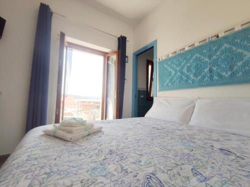 a bedroom with a large bed with a large window at Sisinedda in Siniscola