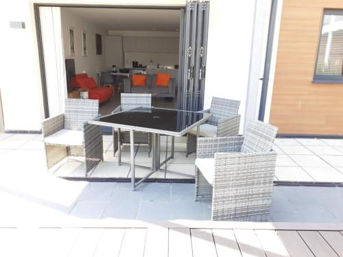 a dining table and chairs on a patio at 3 Putsborough - Luxury Apartment at Byron Woolacombe, only 4 minute walk to Woolacombe Beach! in Woolacombe