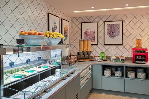 a kitchen with a counter with food on display at Hampton By Hilton Bath City in Bath