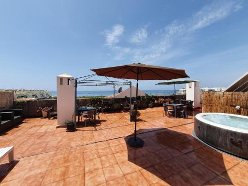 a patio with an umbrella and a pool at Rico Apartaments Ricosol in Torrox Costa