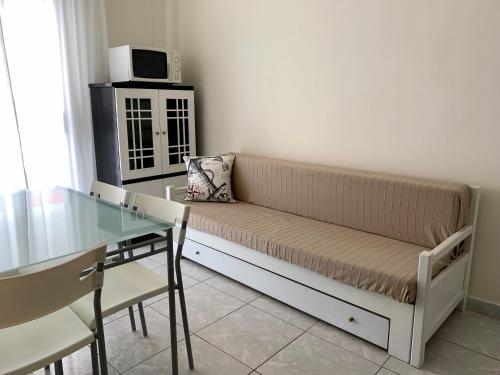 a couch in a living room with a glass table at Uranias Beach House in Kalives Poligirou