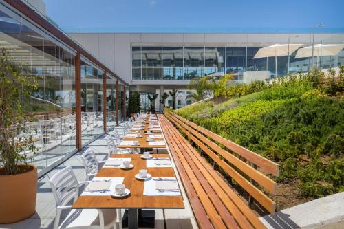 a long row of wooden tables in a building at Barceló Conil Playa - Adults Recommended in Conil de la Frontera