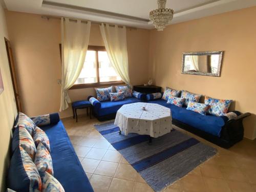 ein Wohnzimmer mit einem blauen Sofa und einem Tisch in der Unterkunft Lilac's Garden Cabo Negro in Cabo Negro