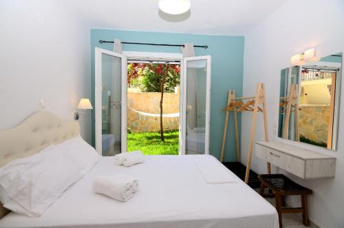 a bedroom with a white bed and a window at Villa Ektoras by EY Villas in Parga