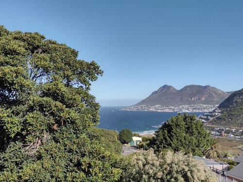 a view of the ocean from a hill with trees at Lark House, Peaceful Mountain Home with Ocean Views and Power Backup in Cape Town