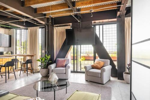 a living room with two chairs and a table at Argentina by Pardela - LOFT nuevo Colonia Americana in Guadalajara