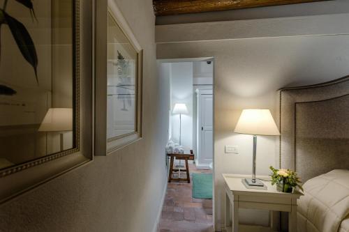 a bedroom with a bed and a table with a lamp at CORTE SAGGIN Charme Relais in San Pietro in Cariano