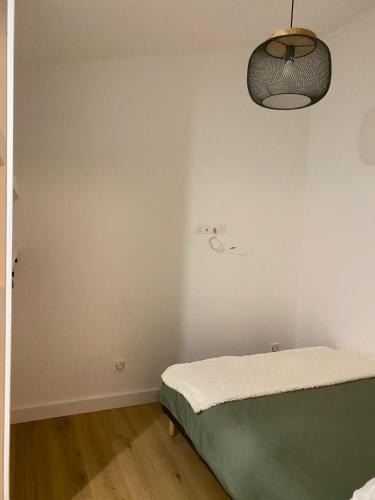 a white room with a bed and a lamp at Mont gozzi in Ajaccio