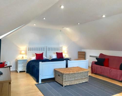 a bedroom with a bed and a red couch at Ossco in Polzeath