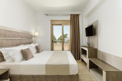 a hotel room with a bed and a television at Aria Garden Suites in Nikiti