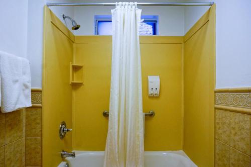 a yellow bathroom with a tub and a shower at Grant Hotel in San Francisco