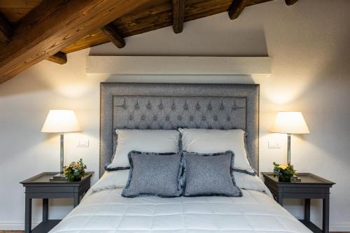 a bedroom with a large white bed with two lamps at CORTE SAGGIN Charme Relais in San Pietro in Cariano