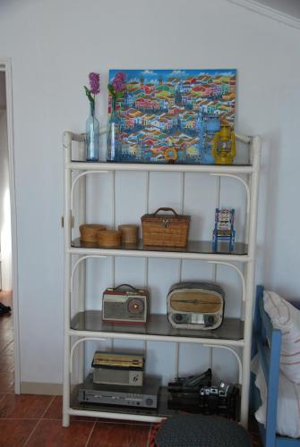 a white shelf with a radio and a box at Monte Ramos in Ferreira do Alentejo
