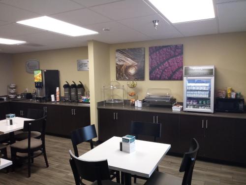 una sala da pranzo con tavoli, sedie e un bancone di Sleep Inn & Suites Wisconsin Rapids a Wisconsin Rapids