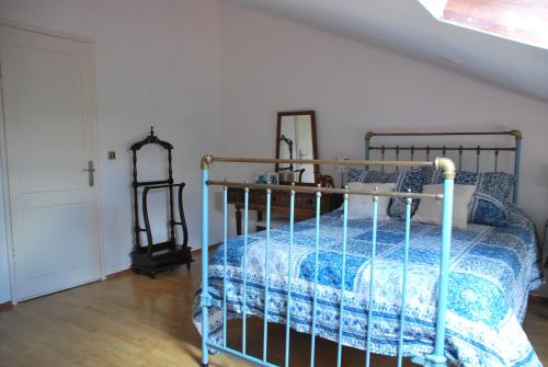 a bedroom with a metal bed with a blue comforter at Monte Ramos in Ferreira do Alentejo