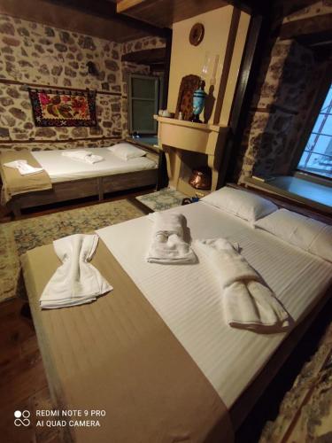 a bedroom with a large bed with towels on it at Bayiri Petit Pension in Litochoro