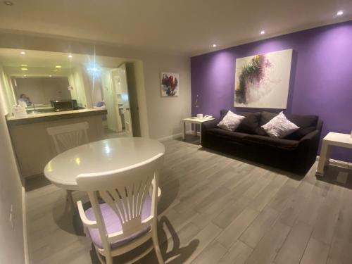 a living room with purple walls and a table and a couch at Rose Hotel in Monterrey