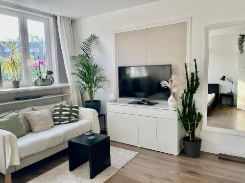 a living room with a couch and a flat screen tv at Apartment in Pempelfort - Central in Düsseldorf