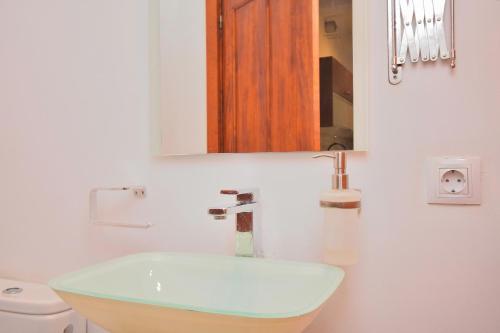a bathroom with a sink and a mirror and a toilet at Casa Anita 257 by Mallorca Charme in Binissalem
