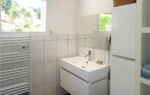 2 Bedroom Cozy Home In Nebian في Nébian: حمام أبيض مع حوض ومرآة