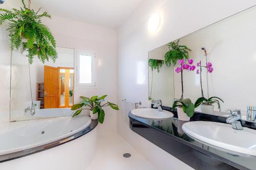 a bathroom with two sinks and two mirrors and plants at Villa Fika, Amazing 3 bedroom Ocean View with Pool in Tías