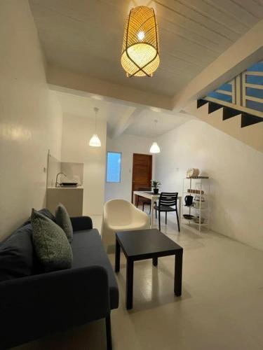 un soggiorno con divano e tavolo di Sto. Niño Whole House w/ 2 AC Bedrooms a Lucena