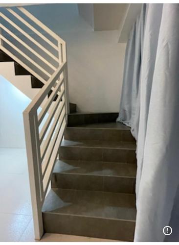 uma escada numa casa com corrimão de escada em Sto. Niño Whole House w/ 2 AC Bedrooms em Lucena
