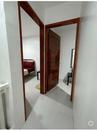 a hallway with a door and a chair in a room at Sto. Niño Whole House w/ 2 AC Bedrooms in Lucena