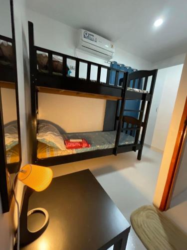 um quarto com 2 beliches, uma secretária e uma cadeira. em Sto. Niño Whole House w/ 2 AC Bedrooms em Lucena