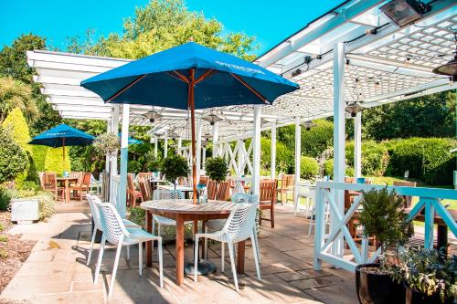 a patio with a table and chairs and an umbrella at The Old Mill in Lymington