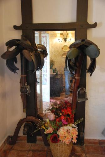a room with a vase of flowers and a mirror at Monte Ramos in Ferreira do Alentejo