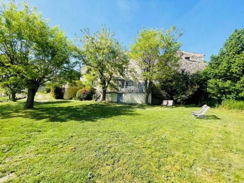 a yard with a bench in front of a house at Gîte La Bastide de La Loge au pied du Mont Ventoux in Sault-de-Vaucluse