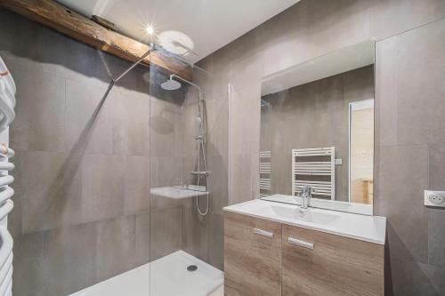 La salle de bains est pourvue d'une douche, d'un lavabo et d'un miroir. dans l'établissement Le Loft, à Ornans