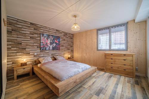 um quarto com uma cama e uma parede de tijolos em Le Loft em Ornans