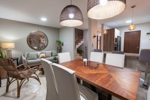 a dining room and living room with a table and chairs at Casa Caracol. Cerca de la playa en residencial privado! in Mazatlán
