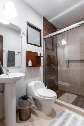 a bathroom with a toilet and a sink and a shower at Casa Caracol. Cerca de la playa en residencial privado! in Mazatlán