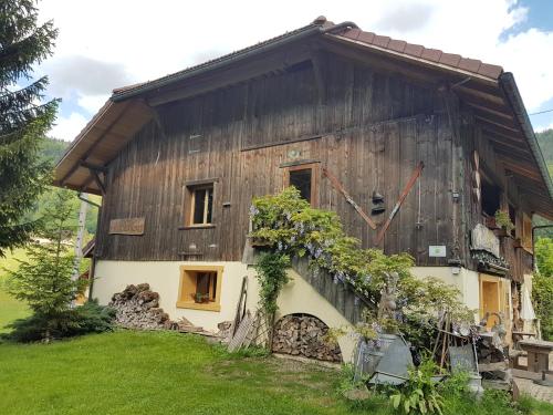 ein Haus mit einem Holzdach und grünem Gras in der Unterkunft Chalet d'en Ô in Les Clefs