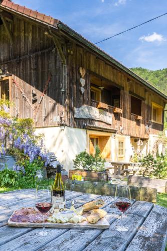 - une table avec deux verres de vin et de nourriture dans l'établissement Chalet d'en Ô, à Les Clefs