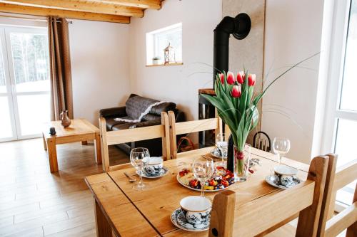 a dining room with a table with a vase of tulips at Ostoja Jaworskie in Stryszawa