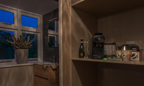 a kitchen with a counter with a coffee maker and a window at Puur & Simpel, Buitengewoon vertoeven in de Brabantse Kempen in Westerhoven