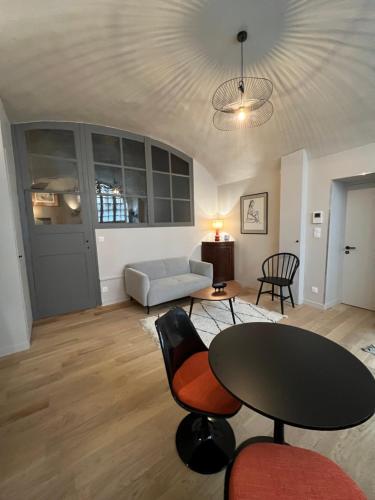 uma sala de estar com uma mesa e cadeiras e um sofá em Unique et charmant 35 m2 Hôtel Particulier XVII ieme Centre Historique Clermont-Ferrand-Lucas II em Clermont-Ferrand